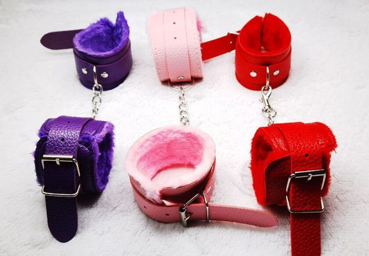 ESPOSAS PARA MUÑECAS O TOBILLOS FABRICADAS EN CUERO SINTETICO, RECUBIERTAS EN SU INTERIOR CON PELUCHE, AJUSTABLES. UNIDAS POR CADENA